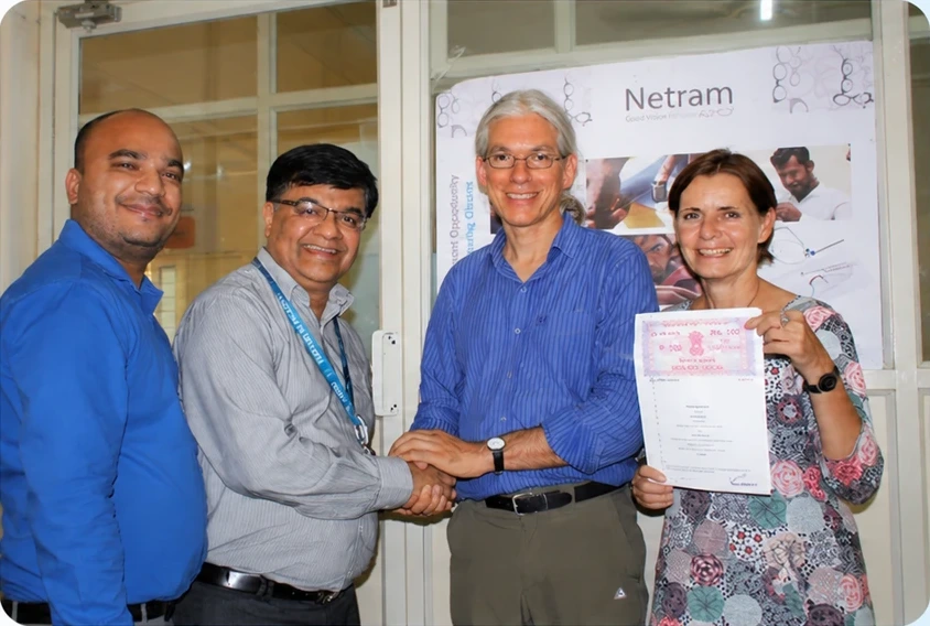 GoodVision International and Care Netram team members shaking hands and holding the signed partnership MoU